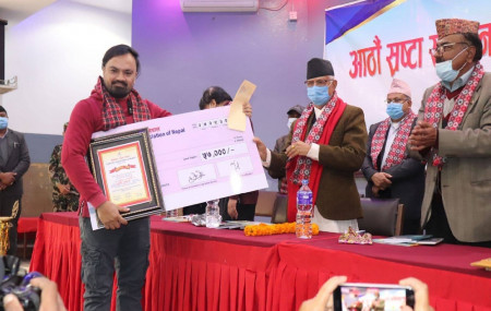 पुरस्कार ग्रहण गर्दै गीतकार महेश आचार्य